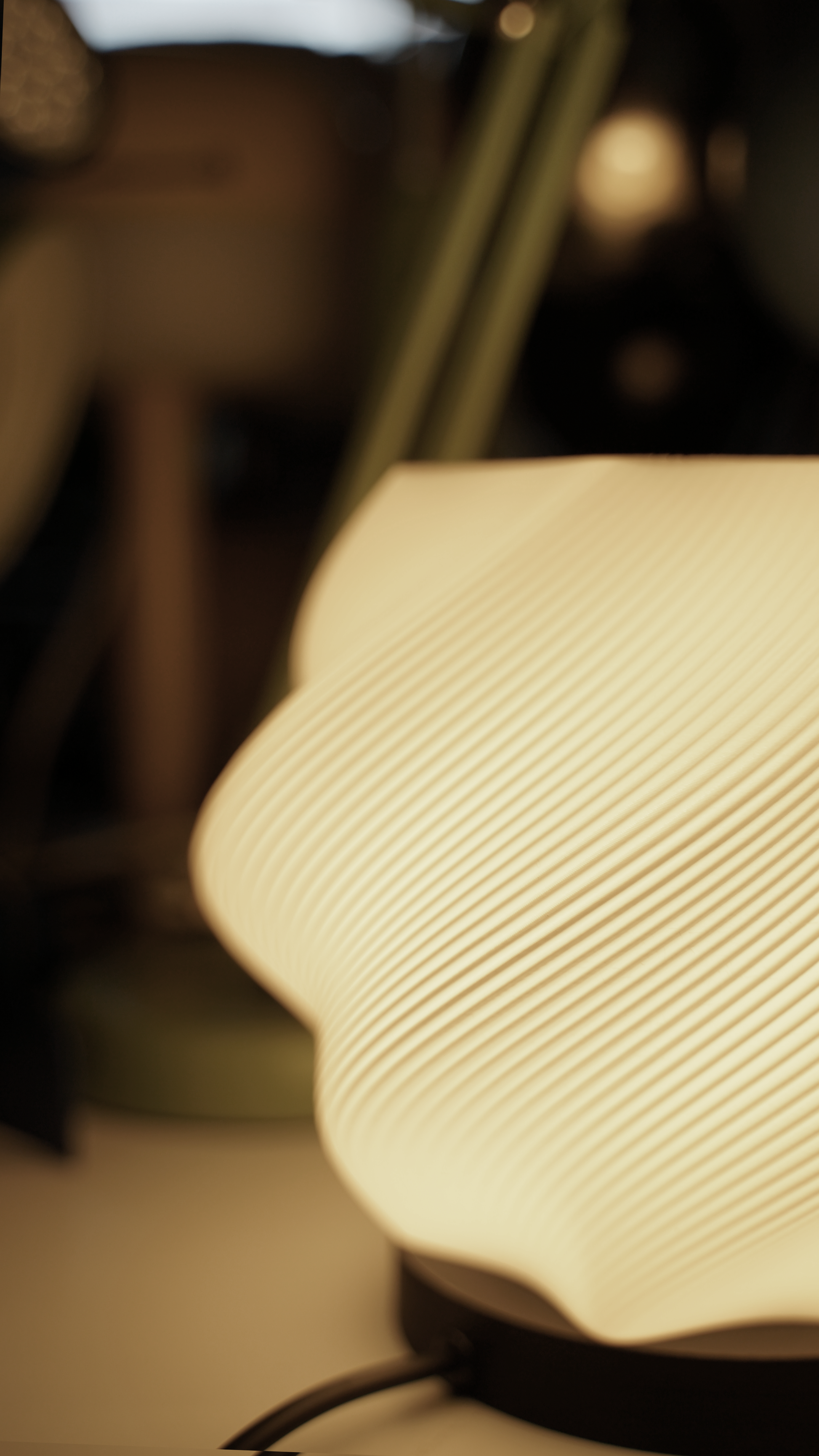 Close-up of the textured, layered surface of the white 3D-printed Swirl lamp, highlighting its organic, grooved design.